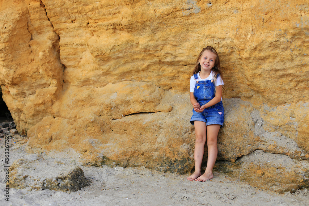 A child on the stones near the sea in summer A child on the stones near the sea in summer