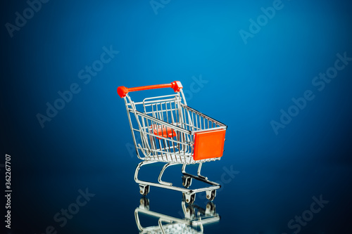 empty shopping cart, blue background