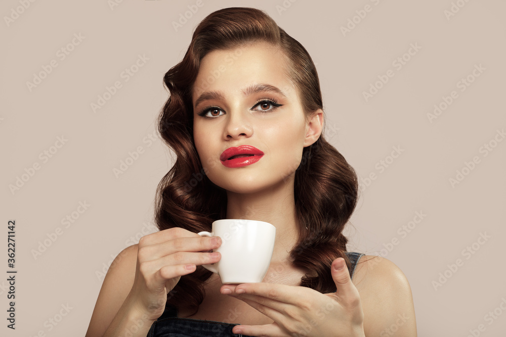Pin-up girl holding a cup of coffee on gray background. Pin-up girl holding a cup of coffee on gray background.