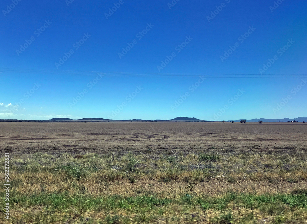 The road trip from Brisbane, Queensland to Melbourne Victoria, showcasing open paddocks, sunshine and blue sky with trees