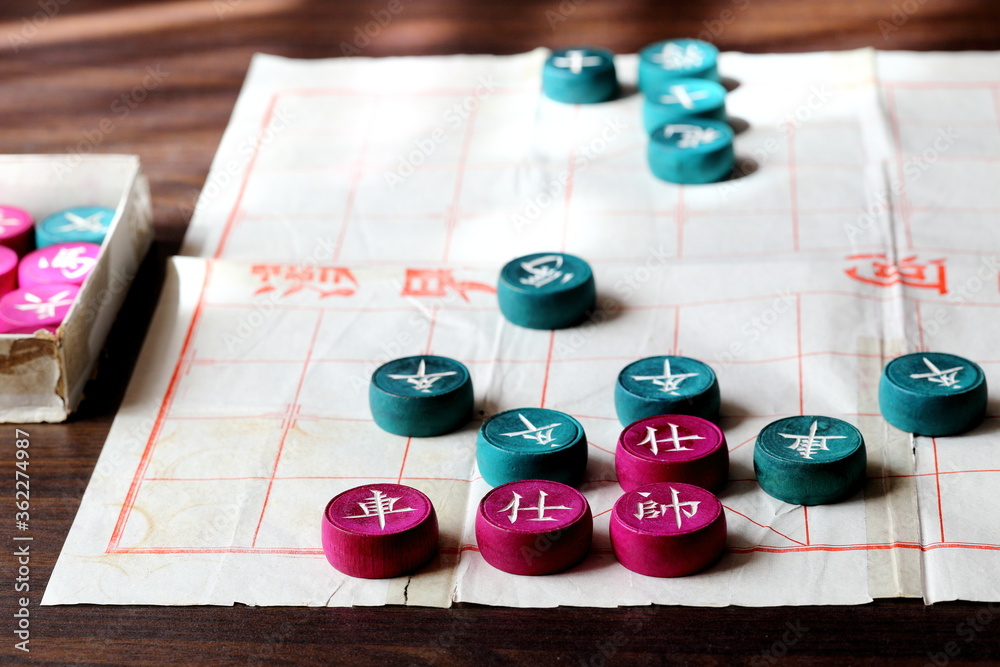 A Game of Chinese Chess Being Played on Paper Board A Game of Chinese Chess Being Played on Paper Board