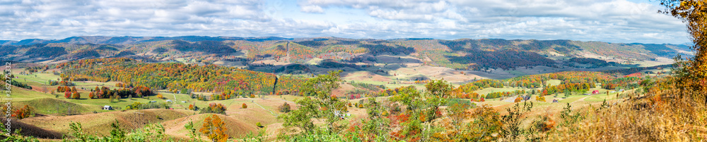 Fall maple trees and panorama of farm house land rolling hills aerial above high angle view landscape in Blue Grass, Highland County, Virginia