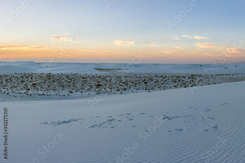 White sands dunes national monument park colorful pastel view in New Mexico with horizon at sunset with silhouette of Organ Mountains
