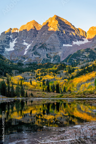 Maroon Bells lake at sunrise in Aspen, Colorado with rocky mountain peak and snow in October 2019 autumn and vibrant trees reflection on water vertical view © Kristina Blokhin