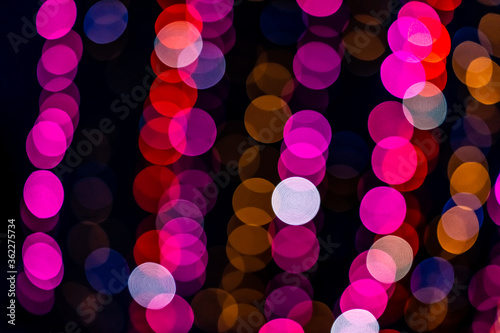Round bokeh abstract circles closeup with red pink neon illuminated decoration lights rows at night evening dark black christmas in Warsaw, Poland