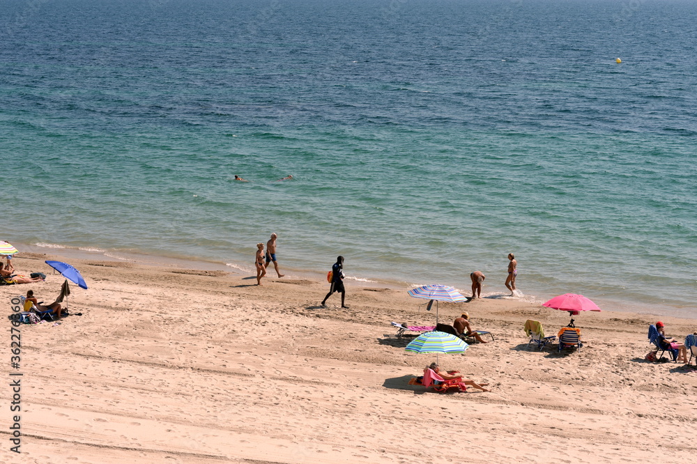 People relax on the sandy beach of Playa de Aguamarina, province of Alicante, Spain People relax on the sandy beach of Playa de Aguamarina, province of Alicante, Spain