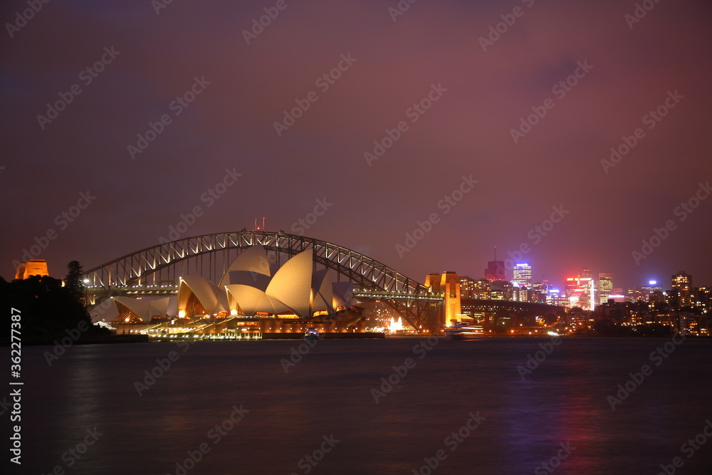 View of the iconic Sydney Opera House and Harbor Bridge at Night, Sydney, Australia.