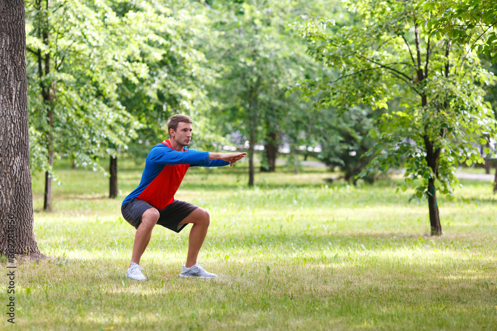 Workout outdoor. Waming up muscles in public park.