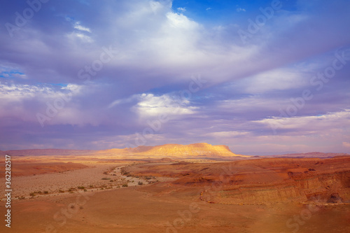Beautiful desert landscape at sunset light with the dramatic evening sky. Mountain on the horizon