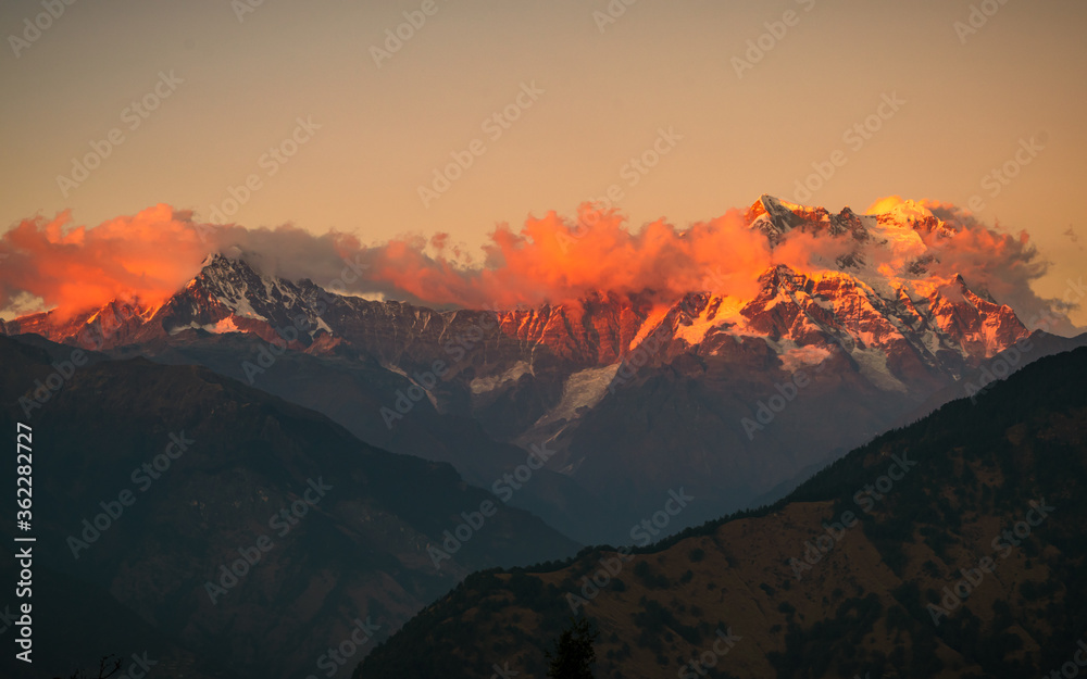 Golden sun rays falling  on snow cladded Chaukambha peaks of Gangotri group of Garhwal Himalayas during sunset from Deoria Tal at Chopta, Uttarakhand, India.
