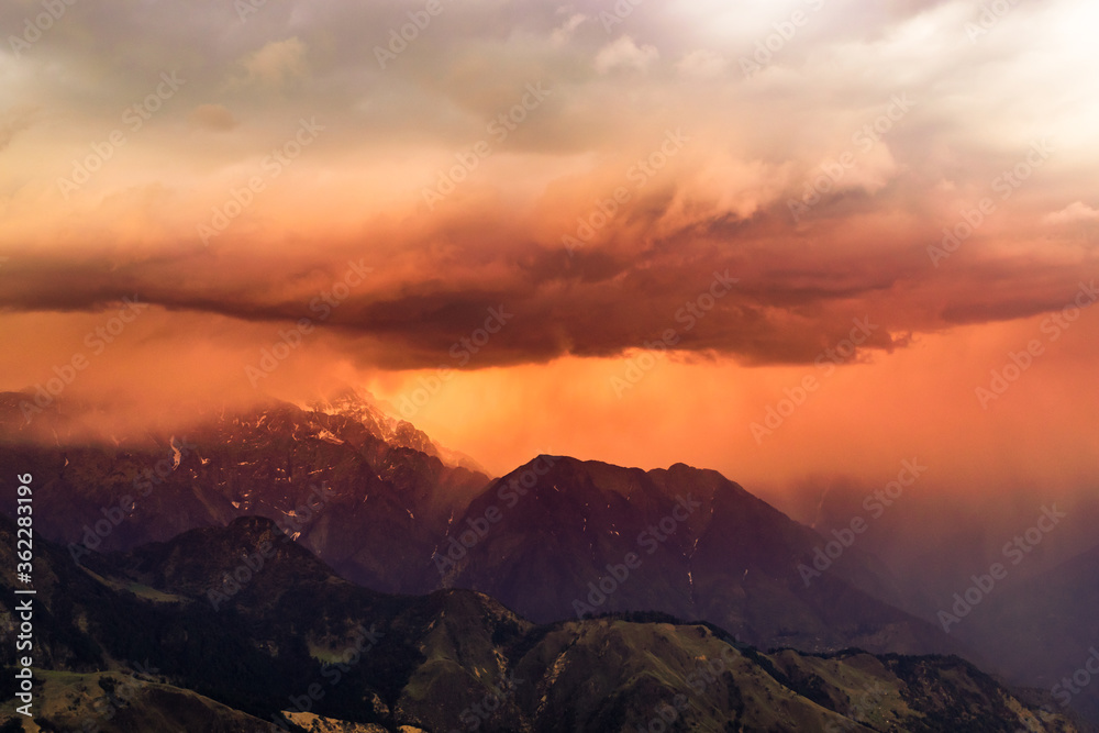 Down-burst rain and snow precipitation  thunderstorm clouds during sunset time formed by western disturbance an extra-tropical storm in great Himalayan region of Uttarakhand, India.