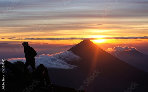 silhouette of a man on the top of the volcano at sunrise