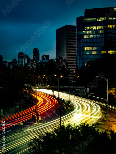 streaks of light trails from cars zooming past the st kilda junction in melbourne during rush hour