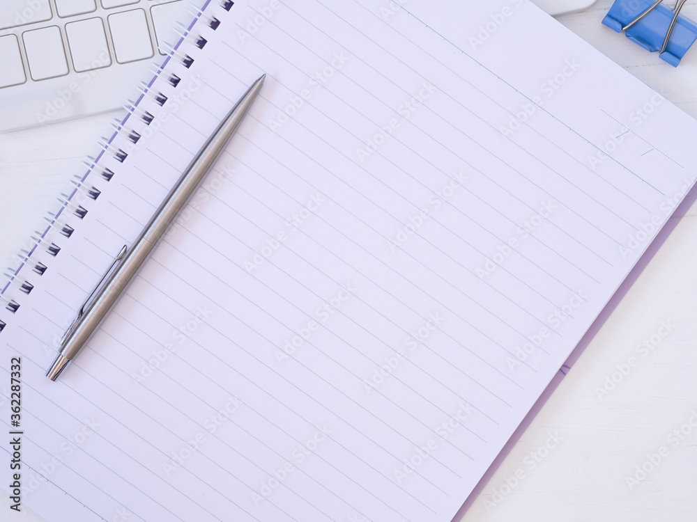 Top view, flat lay notebook and pen with the keyboard on modern white desk, business education concept with space for your text.. Top view, flat lay notebook and pen with the keyboard on modern white desk, business education concept with space for your text..