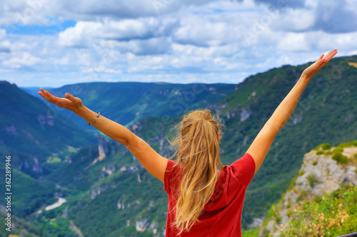 woman rise hand up on top of mountain- Aveyron in France