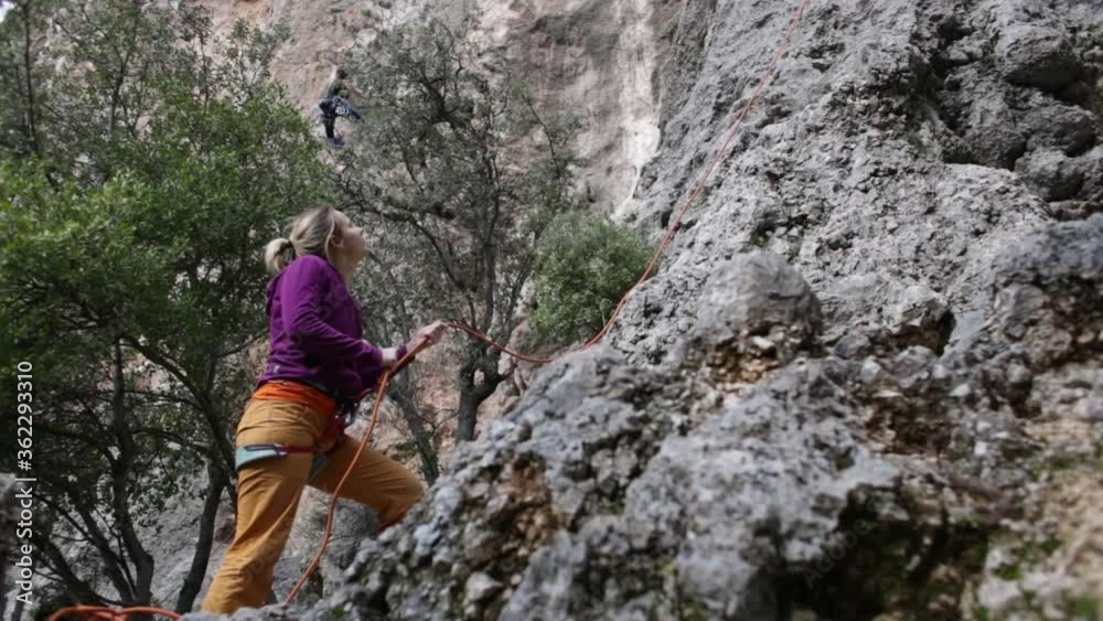 Belaying in rock climbing, Belayer close up, Woman is belaying her partner, Climbing equipment, Rock climbing in Turkey. Belaying in rock climbing, Belayer close up, Woman is belaying her partner, Climbing equipment, Rock climbing in Turkey.