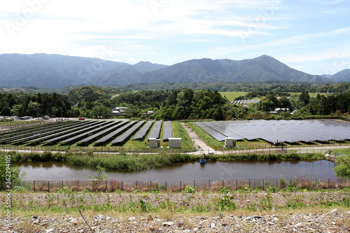 Solar cell panels and villages in rural areas with a background of mountain landscapes in Inabe City, Mie Prefecture, Japan photo