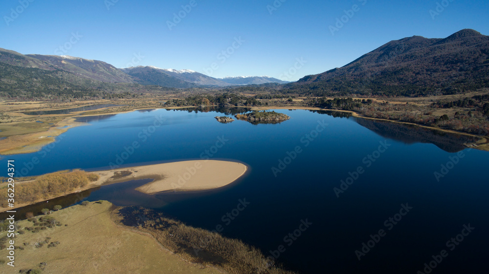 Aerial view of the fresh blue water lake in the mountains, the valley, meadow and forest, in a sunny summer day. Aerial view of the fresh blue water lake in the mountains, the valley, meadow and forest, in a sunny summer day.