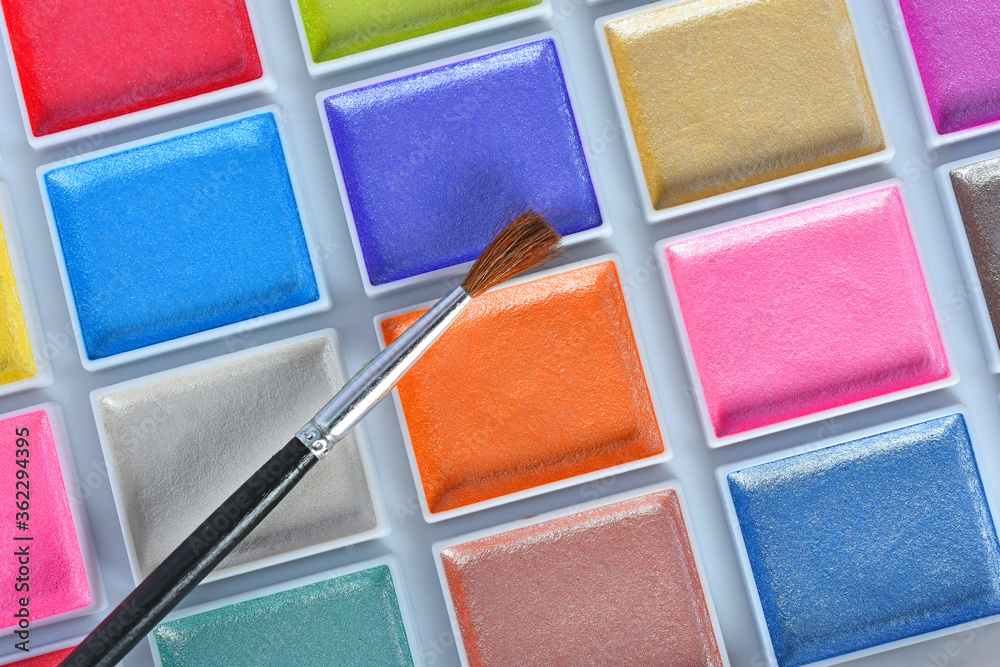 A close up image of a brand new water color paint set in a white plastic case. A close up image of a brand new water color paint set in a white plastic case.