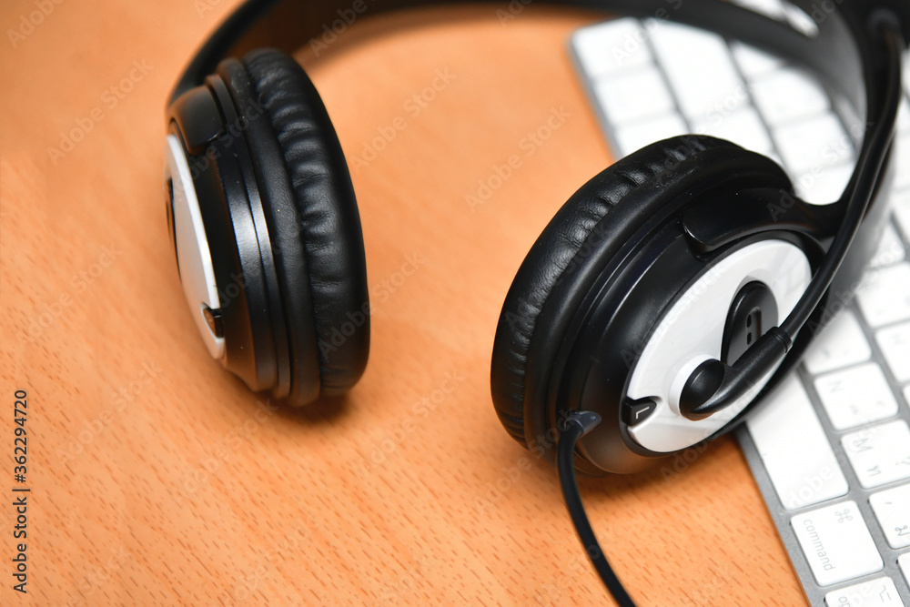 Black headset on table of technical support agent in office Black headset on table of technical support agent in office