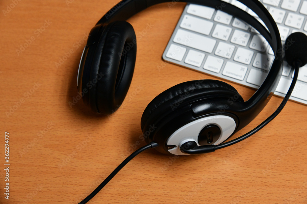 Black headset on table of technical support agent in office Black headset on table of technical support agent in office