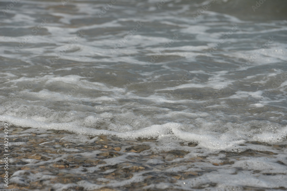 average waves on the sea reach the shore with foam and crash on the rocks with a noise average waves on the sea reach the shore with foam and crash on the rocks with a noise