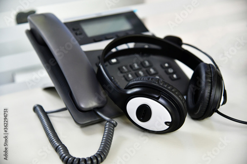 Black headset on table of technical support agent in office