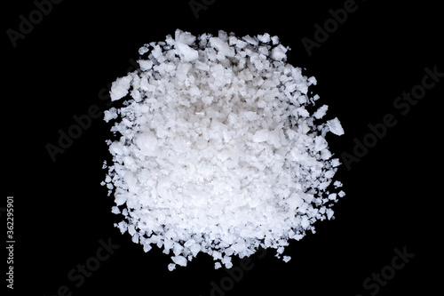 Closeup pile coarse or rock natural sea salt isolated on dark background. Top view. Flat lay.