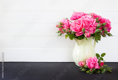 Pink roses bouquet in vase, white wooden background. Empty  blank mock up, poster product design