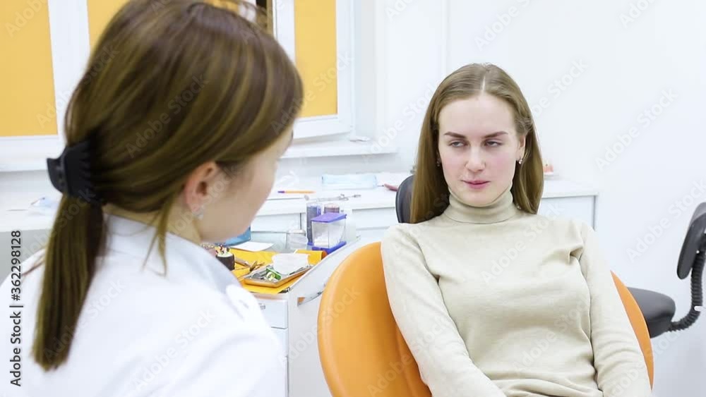 A conversation between a dentist and a patient by a young woman explaining the dental treatment process. A conversation between a dentist and a patient by a young woman explaining the dental treatment process.