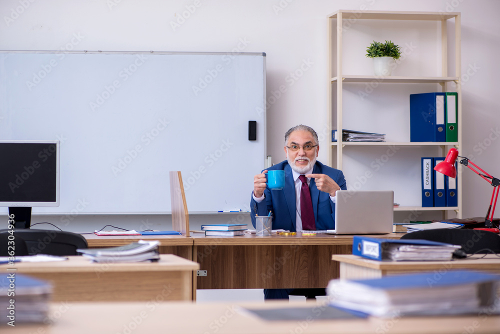 Old male boss employee working in the office Old male boss employee working in the office