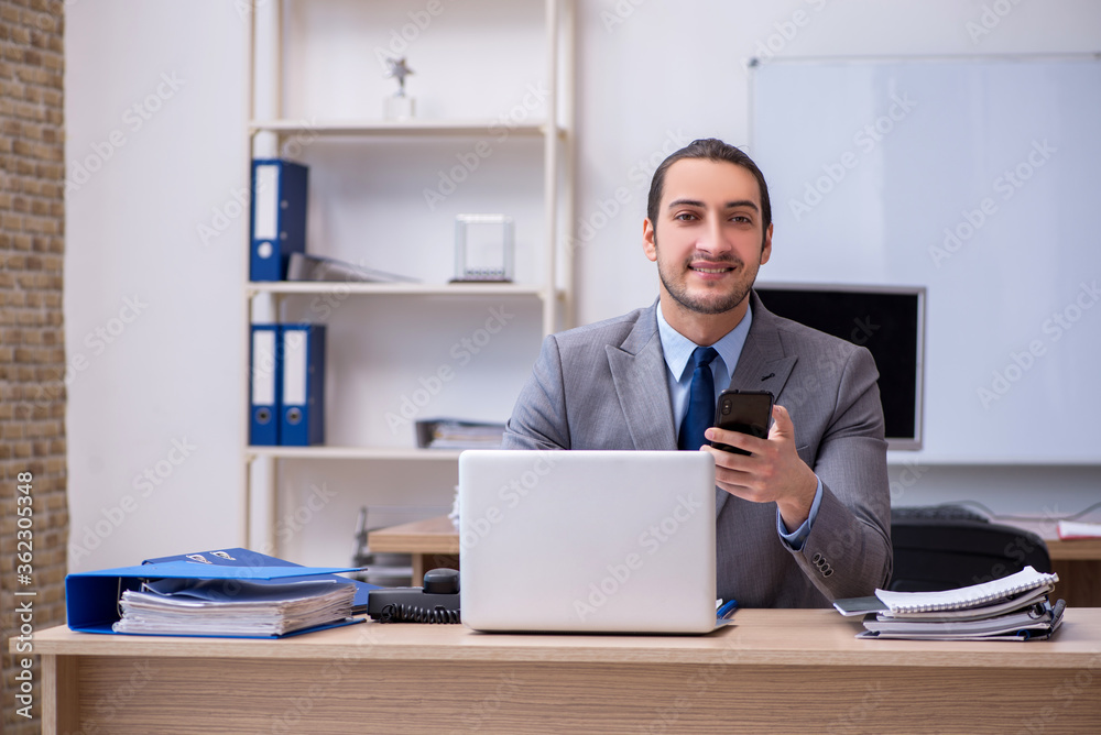 Young male businessman employee working in the office Young male businessman employee working in the office