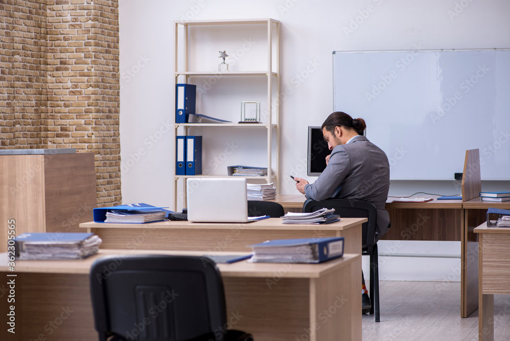 Young male businessman employee working in the office Young male businessman employee working in the office