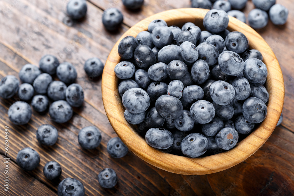 Freshly picked blueberries in wooden bowl on a wooden table. Freshly picked blueberries in wooden bowl on a wooden table.