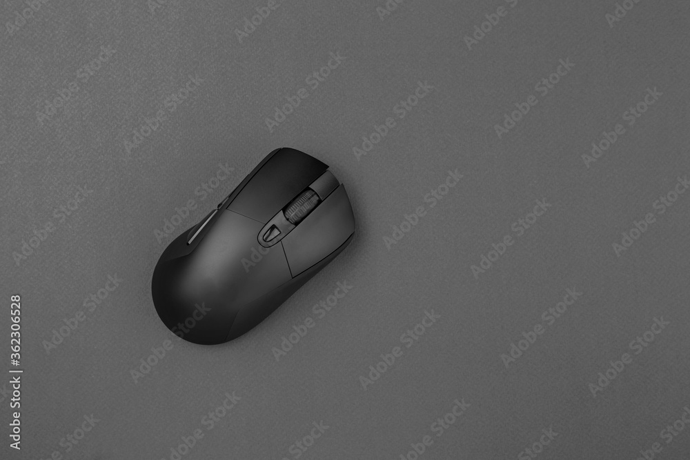 Black wireless mouse on a gray background. Black wireless mouse on a gray background.