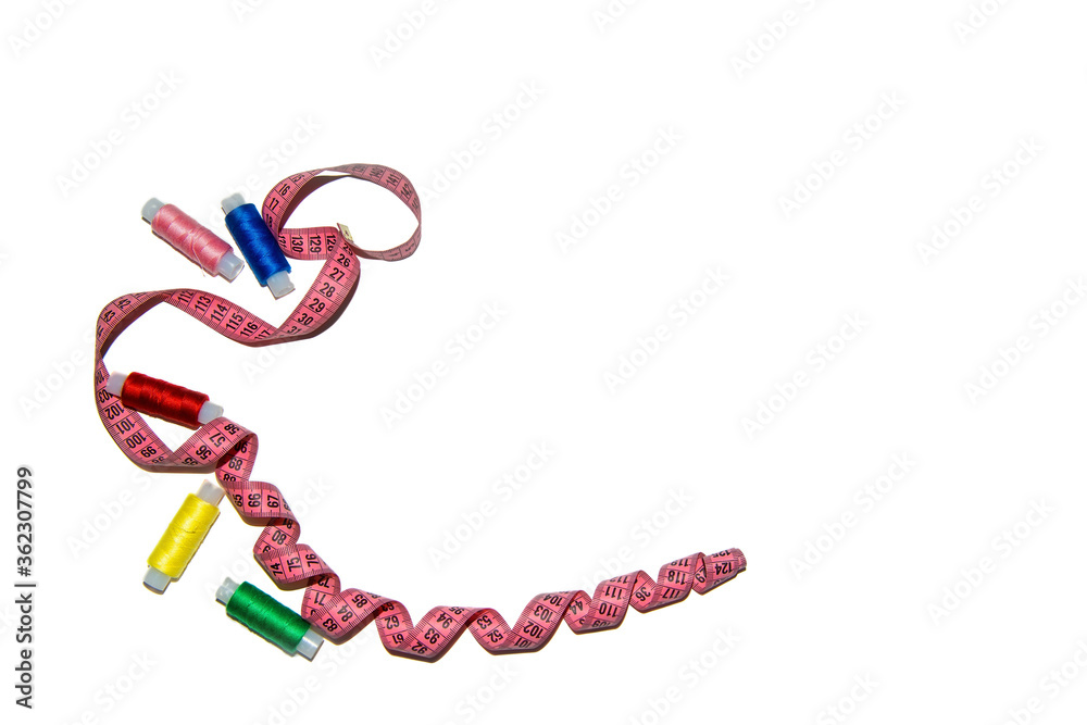 Fototapeta premium Multi-colored sewing threads with a sewing tape on a white background. The view from the top. The image has space for the caption
