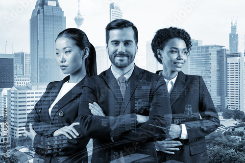 Front view of three successful smiling business consultants standing in a row in suits and ready to tackle with customer problem. Kuala Lumpur cityscape. KL skyscrapers. Double exposure. photo