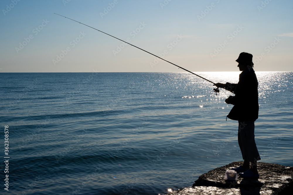 silhouette of a fisherman by the sea silhouette of a fisherman by the sea