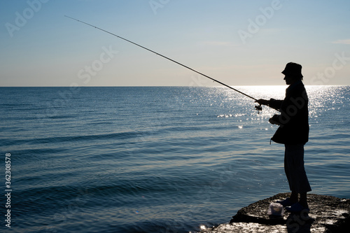 silhouette of a fisherman by the sea