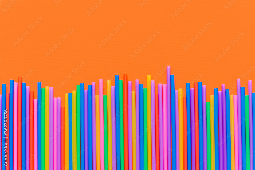 A strip of many plastic colored straws arranged in a row. Isolated A strip of many plastic colored straws arranged in a row. Isolated