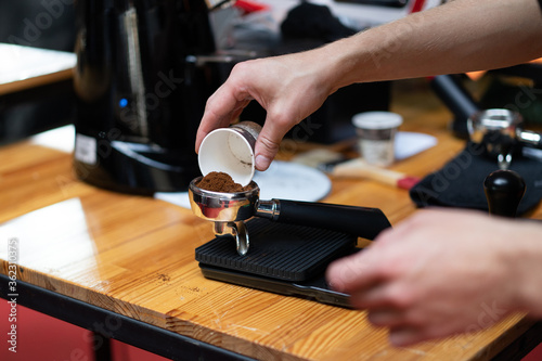 A barista in a coffee machine makes coffee