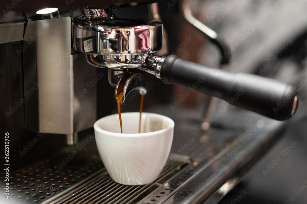 A barista in a coffee machine makes coffee
