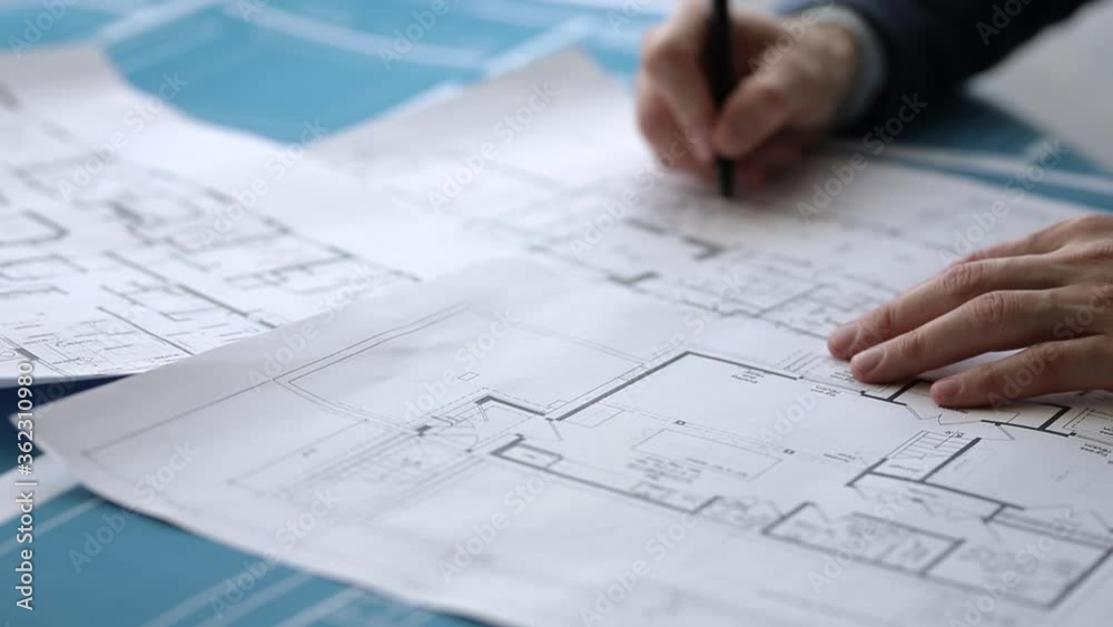 An architect makes notes on construction drawings