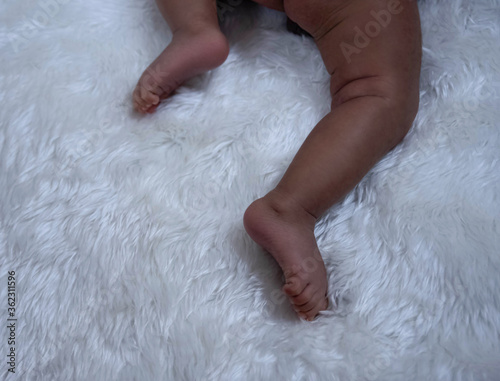 Two feet of newborn baby on silk velvet background