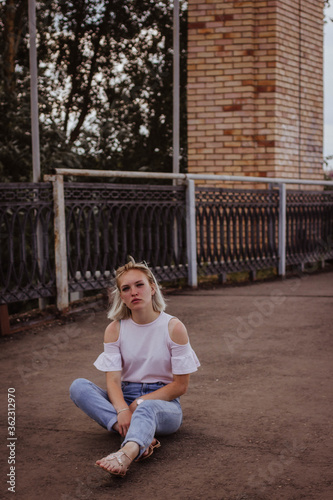 young woman sitting on a bridge