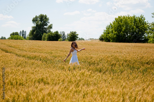 girl in field. feel the freedom. summer harvest. carefree free woman dancing in wheat field. female beauty and health. summer vacation among spikelet. pretty young girl in dress running at field