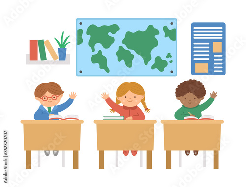 Vector cute happy schoolchildren sitting at the desks with hands up. Elementary school classroom illustration. Clever kids at the lesson. Boys and girl ready to answer teacher’s question..