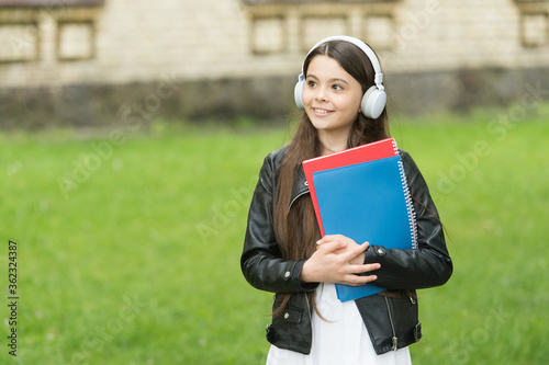 Lesson that sounds. Small learner wear headphones. Little child hold books for lesson. Private lesson. Listening comprehension skills. Music lesson. School and education
