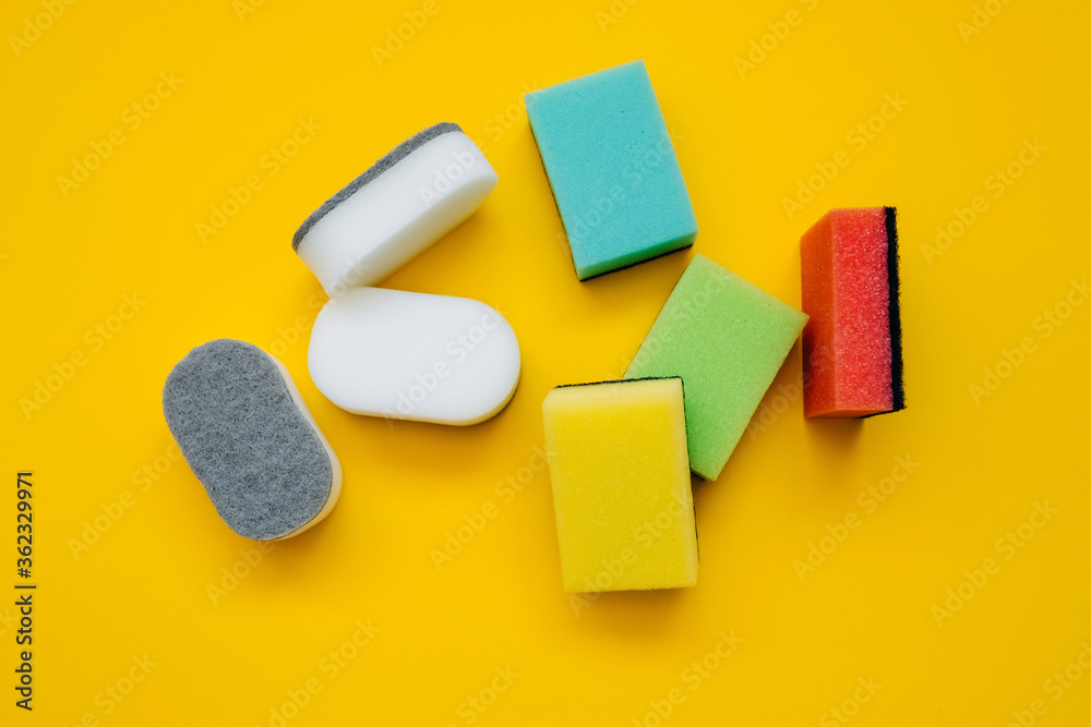 Bunch of white and colorful dish sponges on bright yellow background. Concept of cleaning. Bunch of white and colorful dish sponges on bright yellow background. Concept of cleaning.