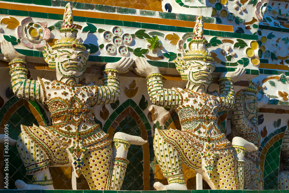 Fototapeta premium Sculptures of Rakshasa demons supporting the main prang of the Temple of the Morning Dawn (Wat Arun). Bangkok, Thailand
